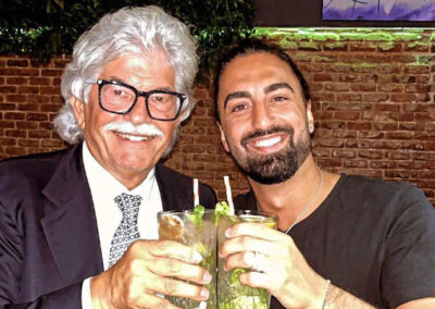 Dos hombres de mediana edad brindan felices mirando a cámara